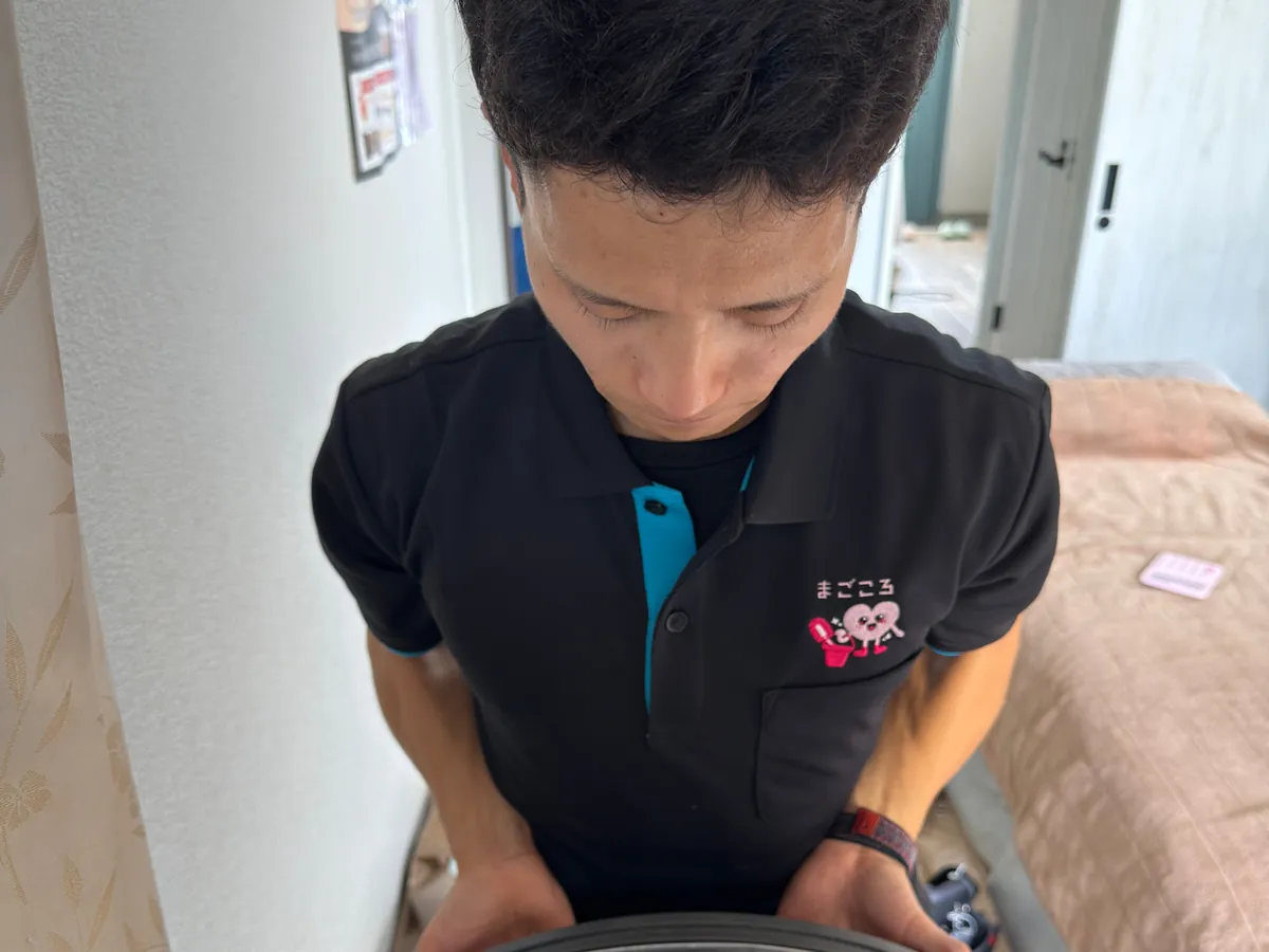 スタッフがドラム式洗濯機を分解している様子